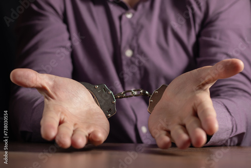 stressed out businessman hands bothered with handcuffs suffering at custody for concept of suspicious business