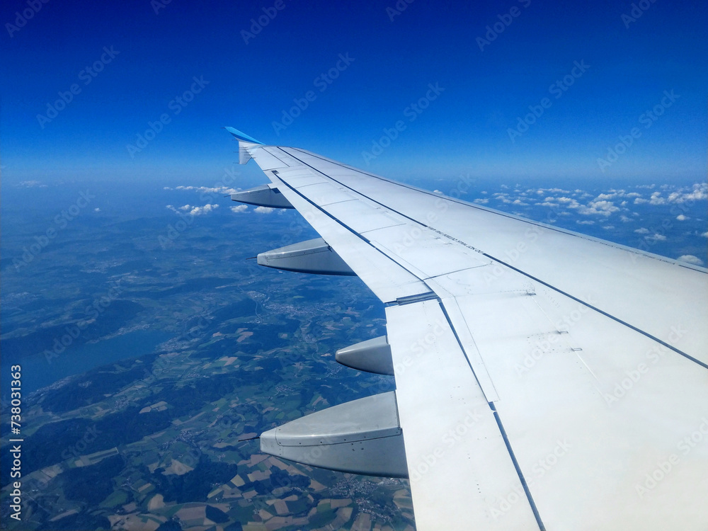Blick aus dem Flugzeugfenster auf Flügel und Landschaft 