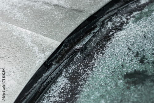 Frozen Car windscreen with wiper blade and hood on frosted windshield glass. Autumn morning frosts © eliosdnepr