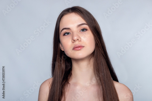 Beautiful Young Woman with Clean Fresh Skin touch own face .