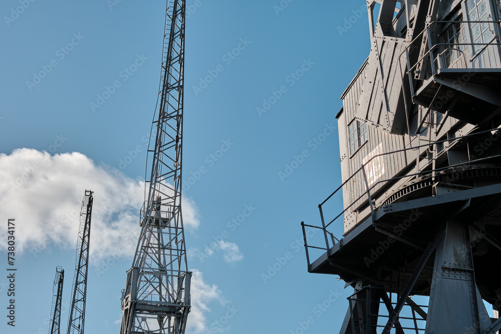 Old disused dockyard cranes against a blue sky Old disused dockyard cranes against a blue sky