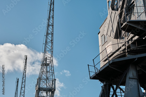 Old disused dockyard cranes against a blue sky