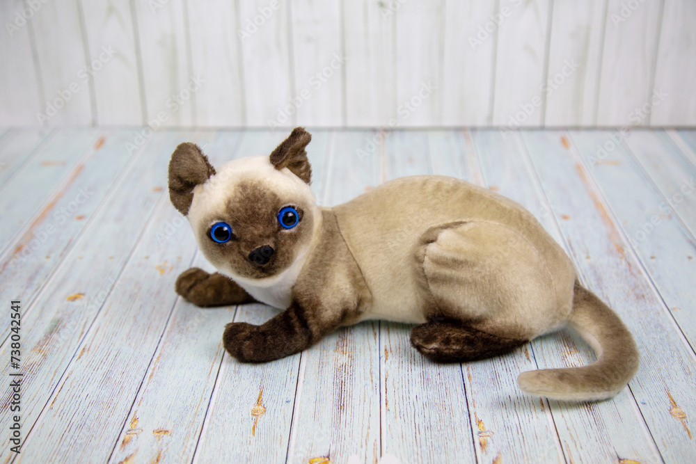 A Siamese cat made of papier-mache gray with beautiful brown paws and a muzzle on a wooden table. Pets Toys Recreation Hobbies.