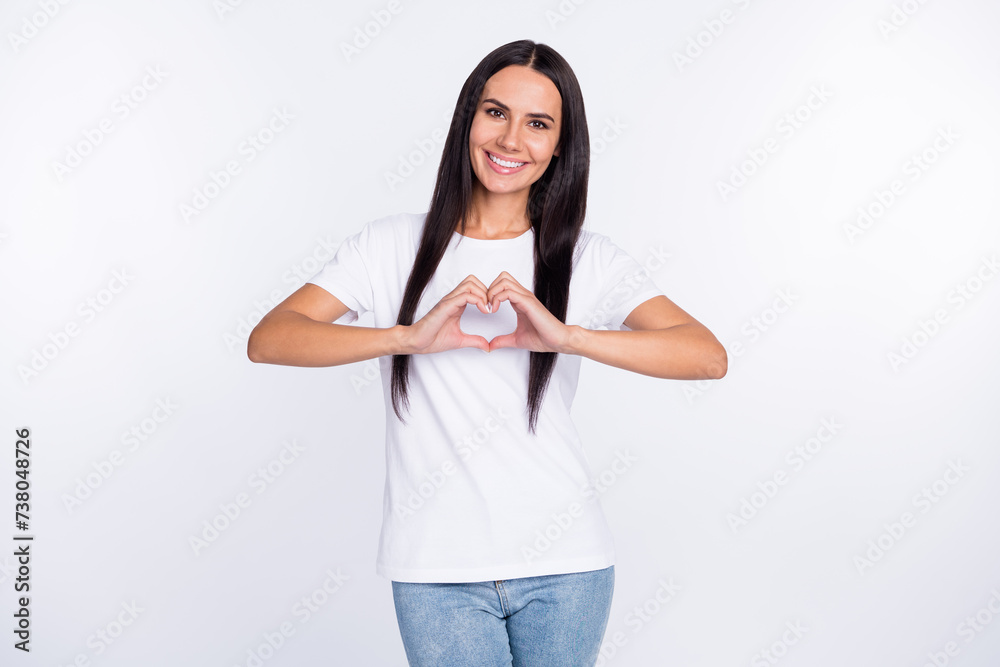 Photo portrait of woman smiling cheerful showing heart with fingers isolated on white color background Photo portrait of woman smiling cheerful showing heart with fingers isolated on white color background