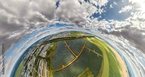 abstract circular curvature of surface of earth and twisting of sky over on farm field of solar panels