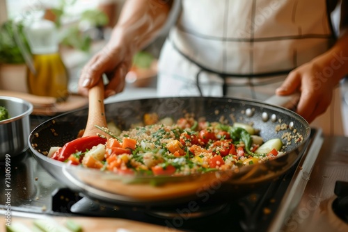 An individual cooks a medley of fresh vegetables, focusing on the stirring motion in a well-equipped kitchen