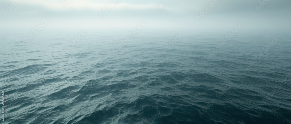a large body of water with waves in the foreground and a few clouds in the sky over the water. a large body of water with waves in the foreground and a few clouds in the sky over the water.