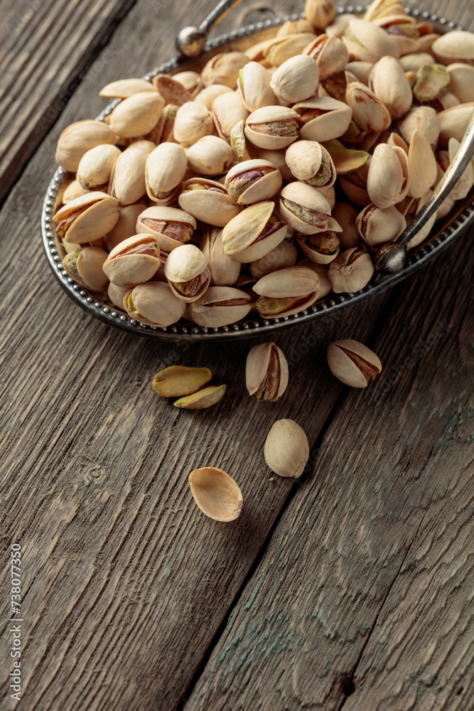 Salted pistachios on an old wooden table. Salted pistachios on an old wooden table.