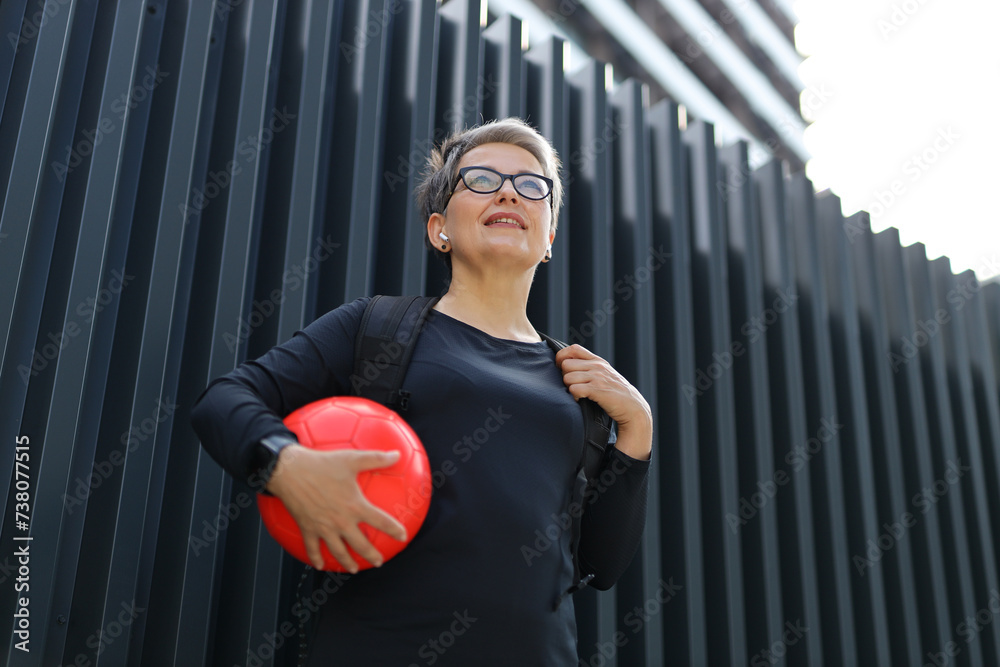 Φωτογραφία A cheerful Caucasian woman enjoys outdoor leisure, holding a ball, and smiling in the summer park