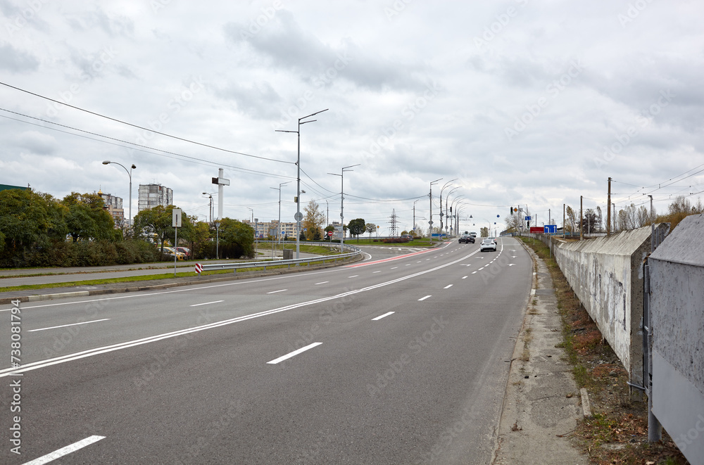 Highway with cityscape of Kyiv, Ukraine. Protective rail on the road. Roadway in the city