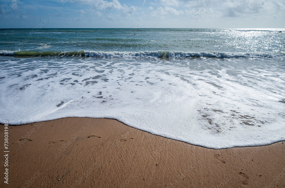 Curvy shape of gentle waves on sandy beach on Isle Of Wight in summer
