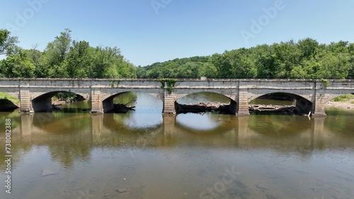 Monocacy Aqueduct with stone arches and bike trail in Maryland by the Potomac River part of C&O Chesapeake & Ohio canal system with landscape with green trees and river in summer time sunshine