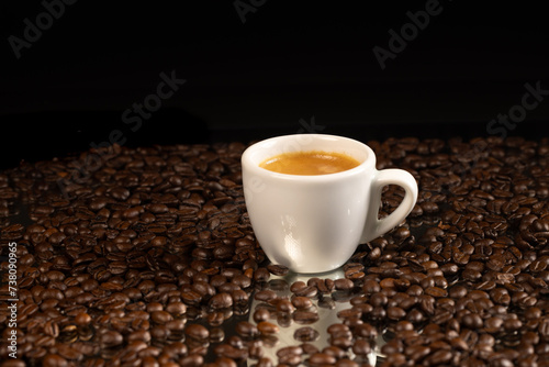 espresso coffee in white cup and coffee beans background