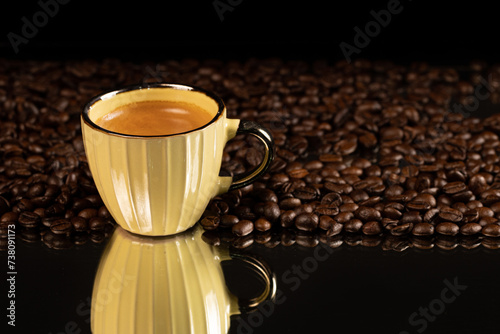 yellow coffee cup with coffee beans on table photo