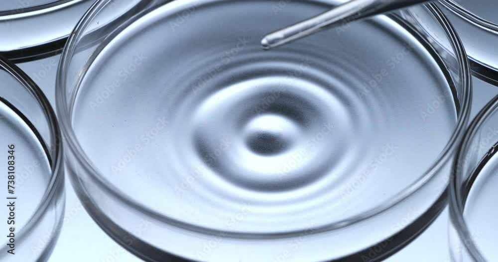 Super slow motion macro of dripping drop of DNA sample substance molecules is being added by scientist to petri dish during biochemical analysis of experimental data research in laboratory at 1000 fps