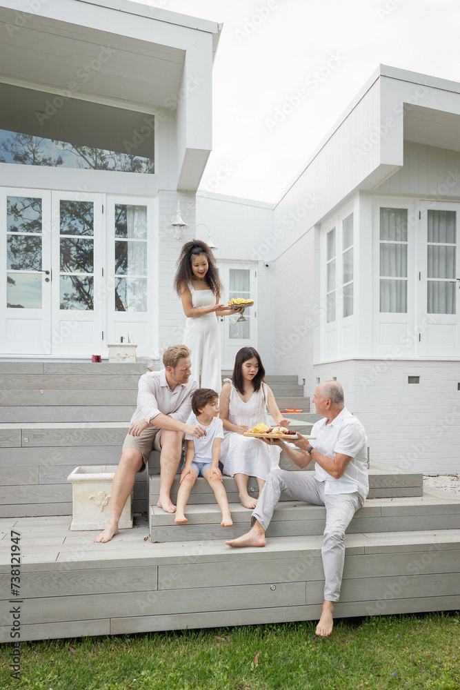 Family eating snacks on backyard stairs Family eating snacks on backyard stairs