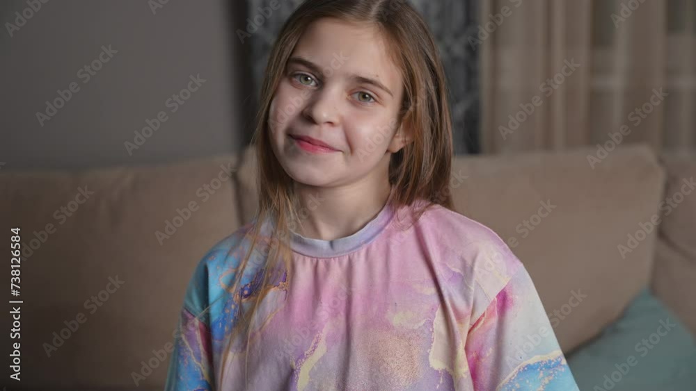 Portrait of smiling girl at home. Happy child looking to camera and smiles on the living room background. Women's day concept