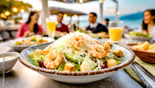 Salat mit Garnelen, im Hintergrund ein Restaurant mit Menschen  photo