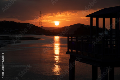 View of the sunset with wooden bridge at the seaside © 안구정화