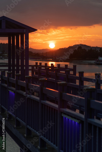 View of the sunset with wooden bridge at the seaside © 안구정화