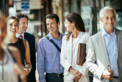 Group of professional colleagues laughing and walking together in the city
