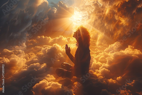 a man kneels and prays, hands folded and raised, and a ray of light falls from the sky
 photo
