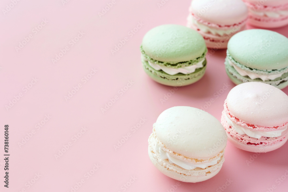 French sweet macaroons in soft colors on light pink backdrop
