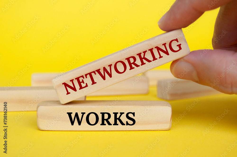 Obraz premium Hand placing wooden block on yellow cover with text - Networking works