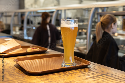 A glass of beer on a tray on the food counter in fast-food café. photo