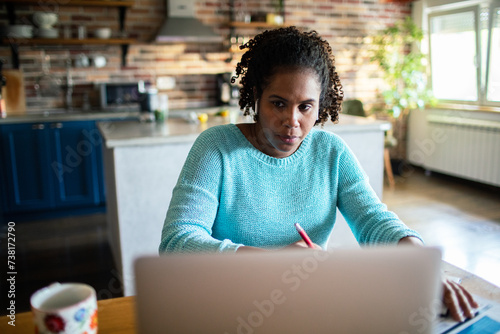 Young woman working from home with a laptop photo