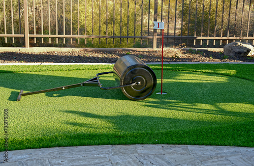 A sod roller on an artificial turf backyard putting green.