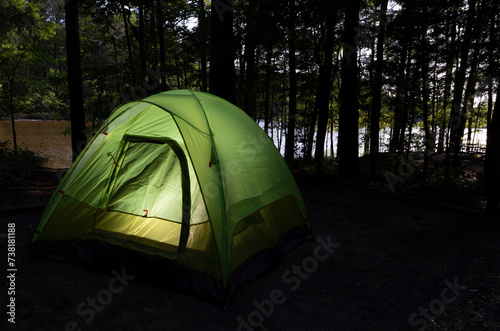Camp with a tent and lake behind © Guy Sagi