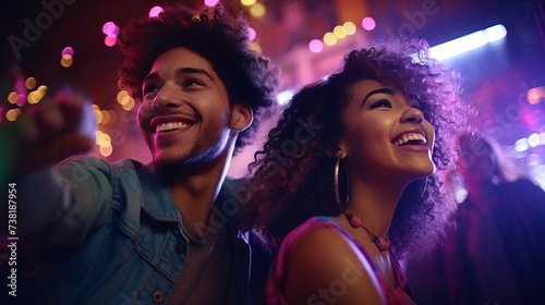 Two happy positive multi-ethnic youth dancing moving rhythmically in good mood at home party, male and female friends having fun energetically moving in room in neon disco light, retro style concept
