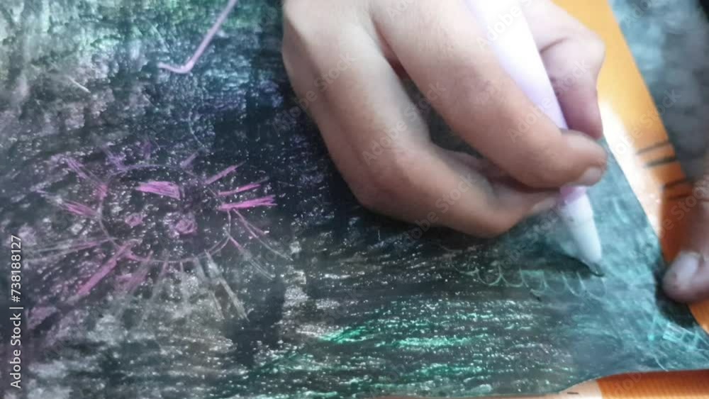 Little girl doing art on a colourful papaer