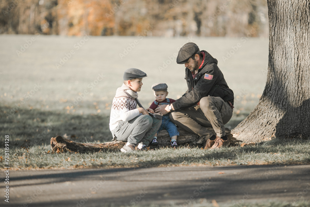 Fototapeta premium Fathers Day. Brothers and their dad enjoying time together in nature.Candid real family moment.
