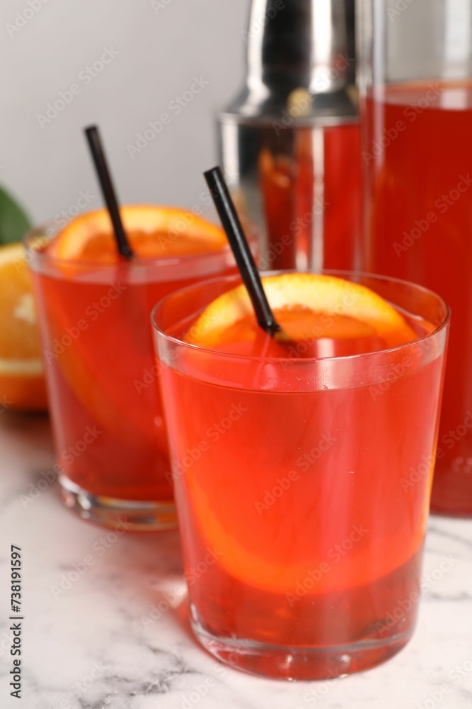 Aperol spritz cocktail, orange slices and straws in glasses on white marble table, closeup Aperol spritz cocktail, orange slices and straws in glasses on white marble table, closeup