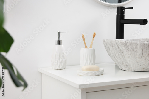 Different bath accessories and personal care products on bathroom vanity indoors