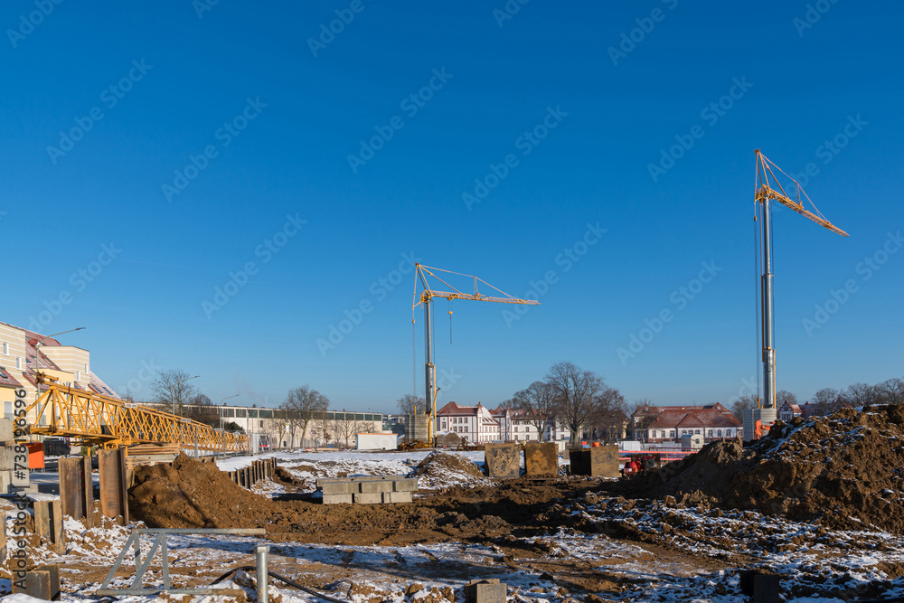 Construction site during the start of excavation work. Construction cranes in the background.