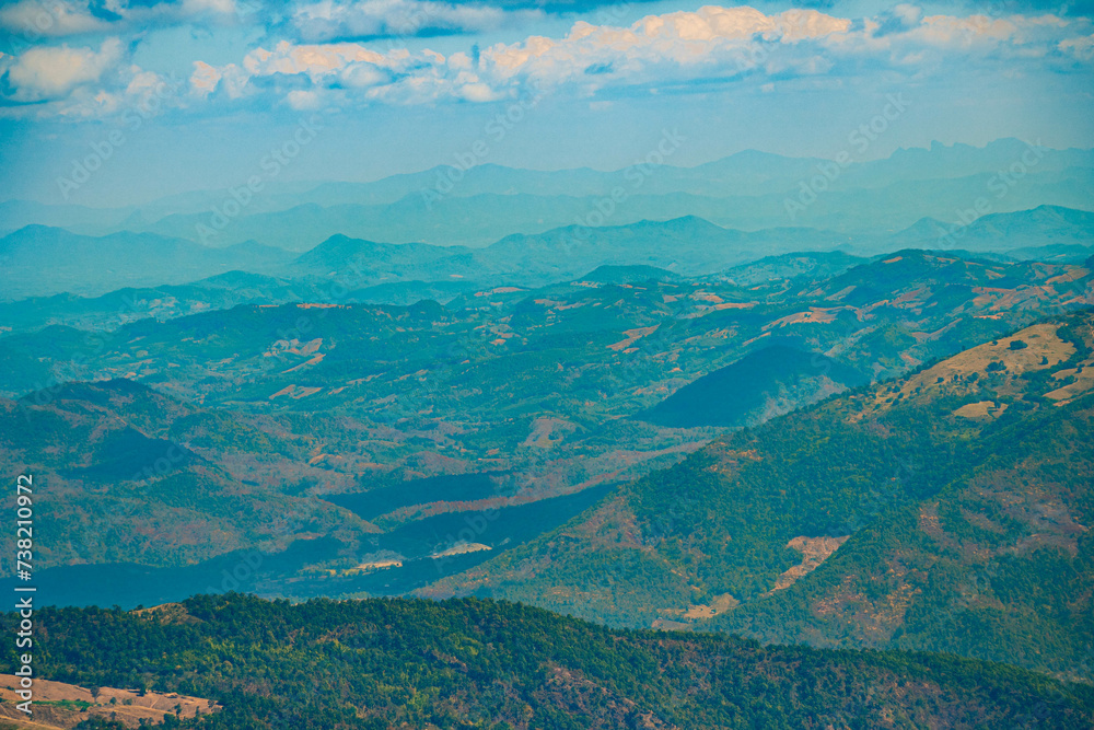 Obraz premium The stunning view in Forest Park from a tourist's standpoint as they go down a hill with background of blue sky, Rainforest, Thailand. Bird's eye view. Aerial view. 
