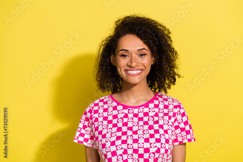 Photo of lovely cheerful girl beaming smile wavy hairdo empty space isolated on yellow color background © deagreez