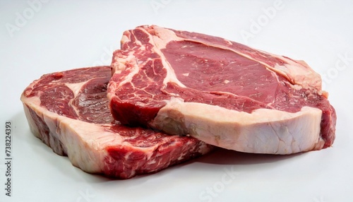 Two rib eye steaks one on top of another on white background. Raw beef meat.