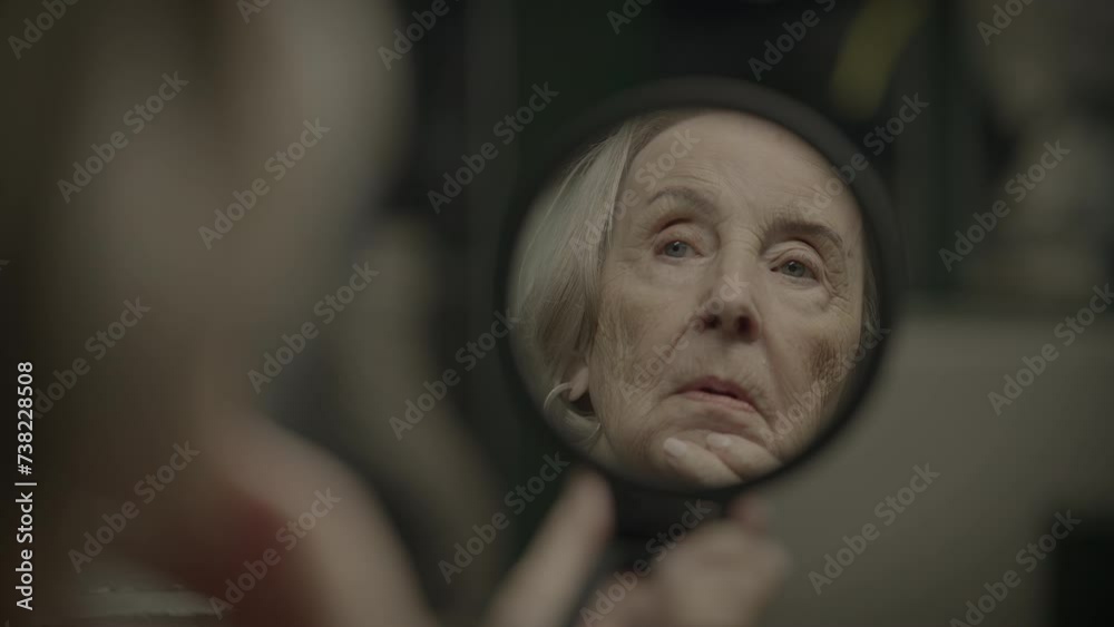 Sad Elderly Woman Watching Herself in Mirror Thinking About the Past Sad Elderly Woman Watching Herself in Mirror Thinking About the Past