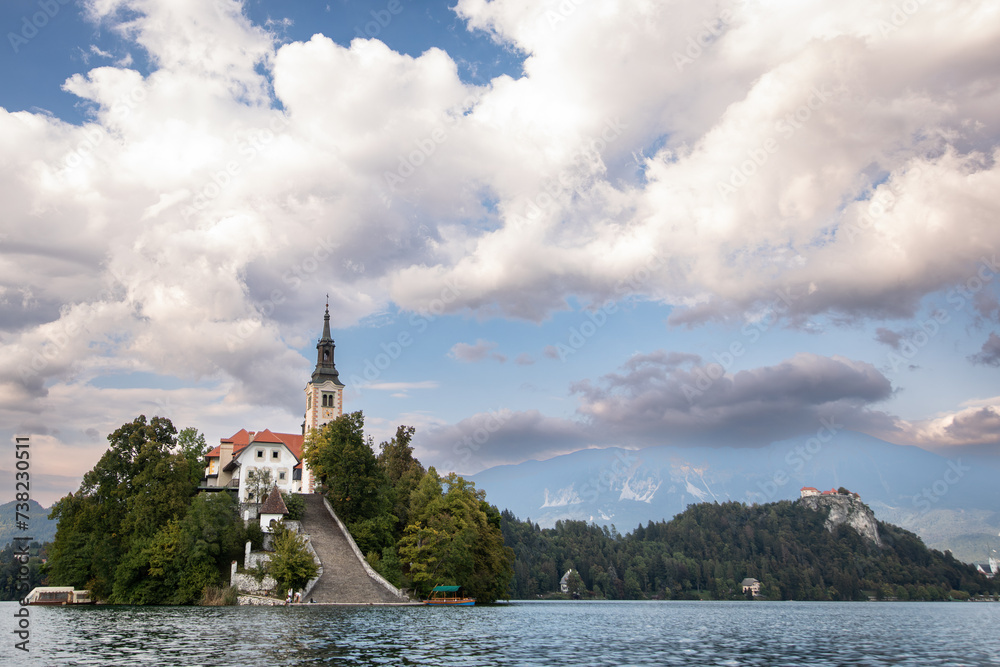 View of the church on an island on Lake Bled with mountains in the background in Slovenia, Europe.