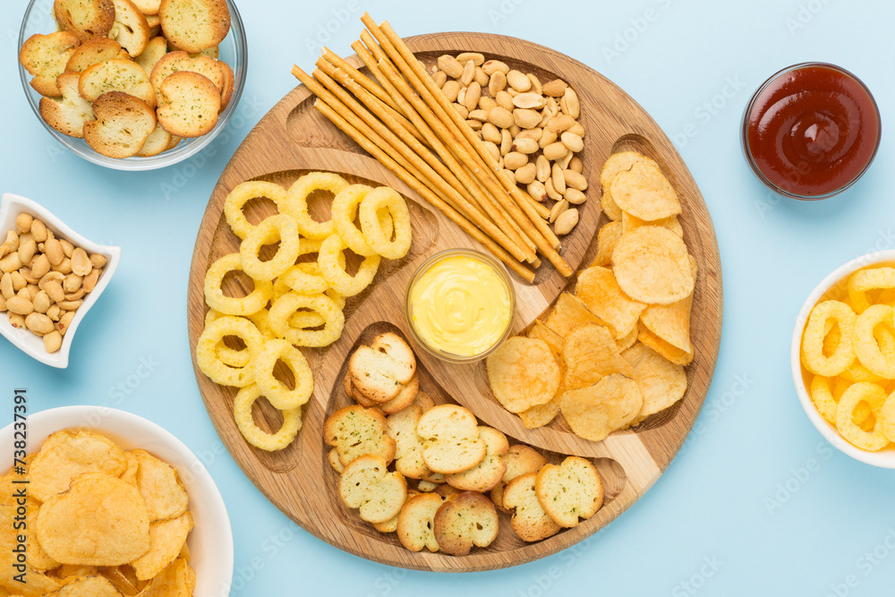Board with unhealthy snacks on wooden background, top view Board with unhealthy snacks on wooden background, top view