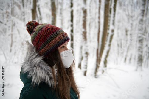 Thoughtful Gaze: Woman in a Mask Amidst a Snowy Forest
