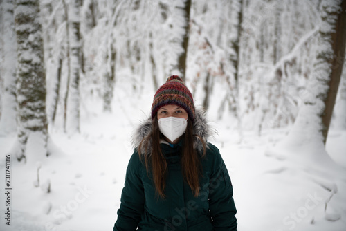 Woman in Winter Attire Standing in a Snowy Forest