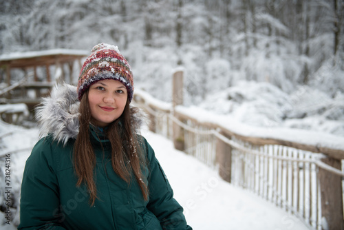 Contented Woman on a Snowy Bridge in a Winter Forest