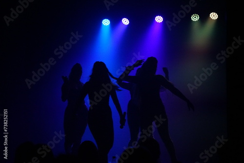 People dancing in the dark with nightclub lights
