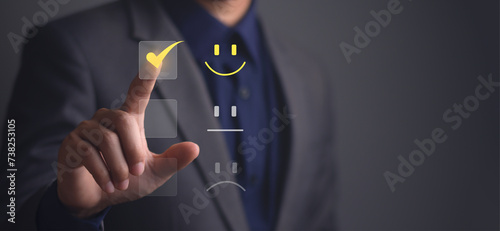 Business man is touching the virtual screen on the happy yellow face smile icon to give satisfaction in service. the best service and Satisfaction concept, rating quality very impressed.