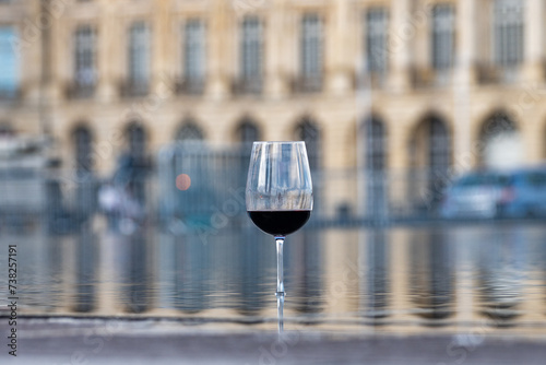 Tasting of Bordeaux blended red wine with wine city Bordeaux on background, left bank of Gironde Estuary, France. Glass of red French wine. © barmalini